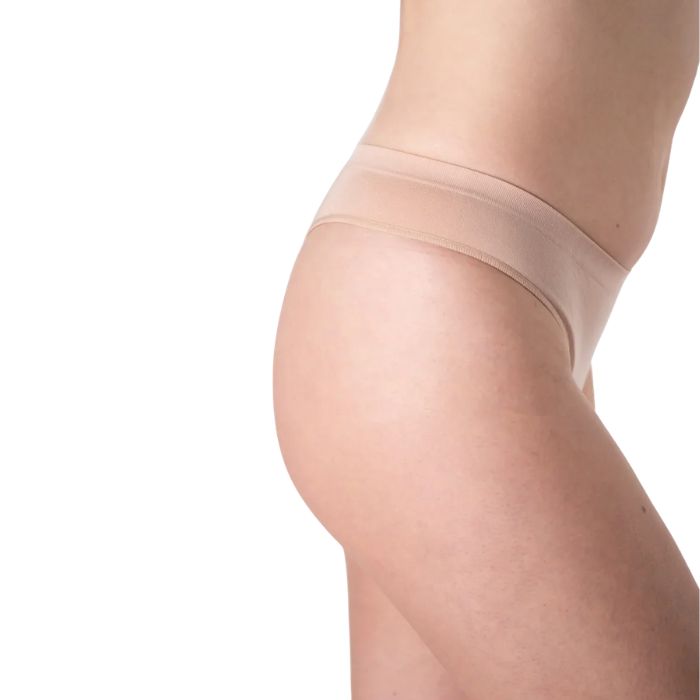 female model wearing beige thong underwear front view on white background
